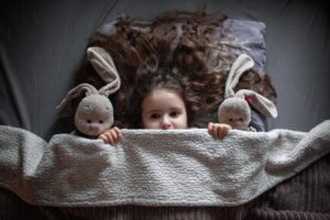 Petite fille apeurée cachée sous la couverture 
